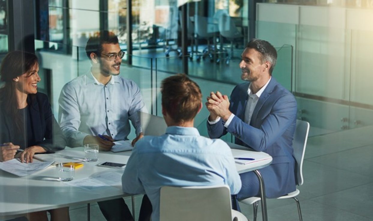 Vier Personen in einem geschäftlichen Meeting an einem runden Tisch